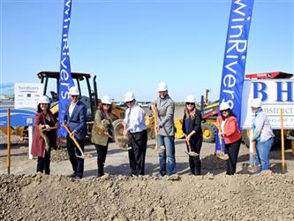 people breaking ground with hard hats and shovels